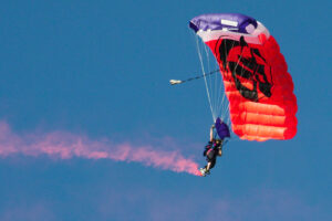 Photo of person parachuting with red smoke